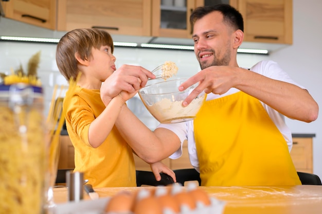 Père et fils essayant de faire une pâte