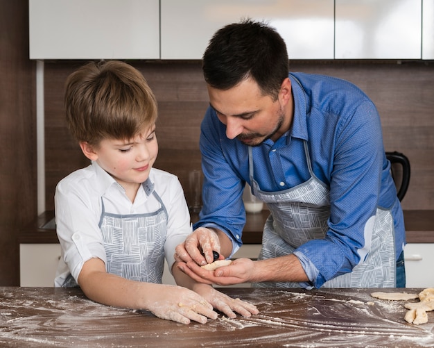 Père et fils faisant des formes de pâte