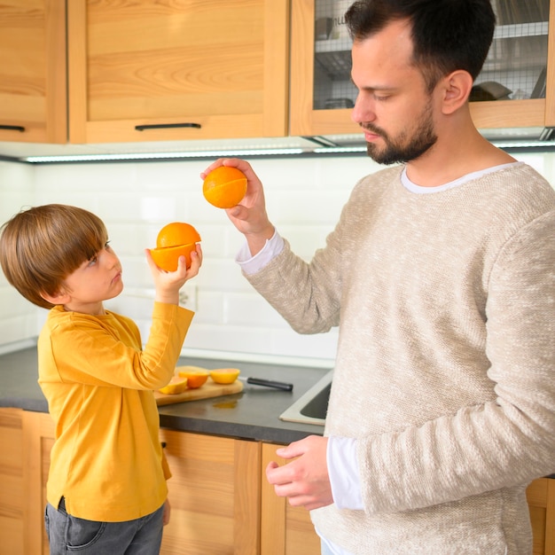 Père et fils high five avec des oranges