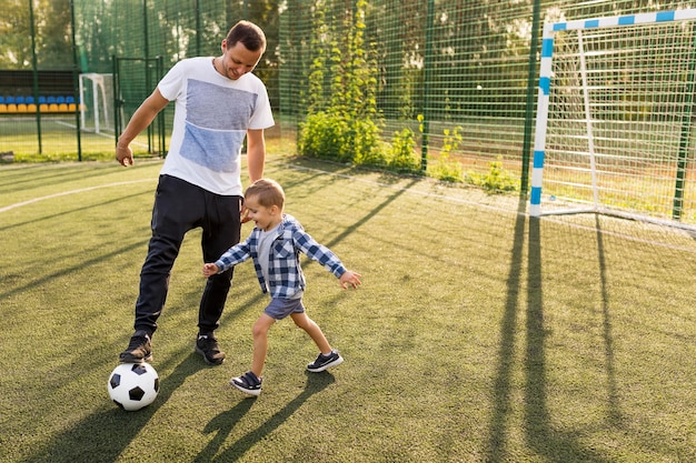 Père et fils jouant au football