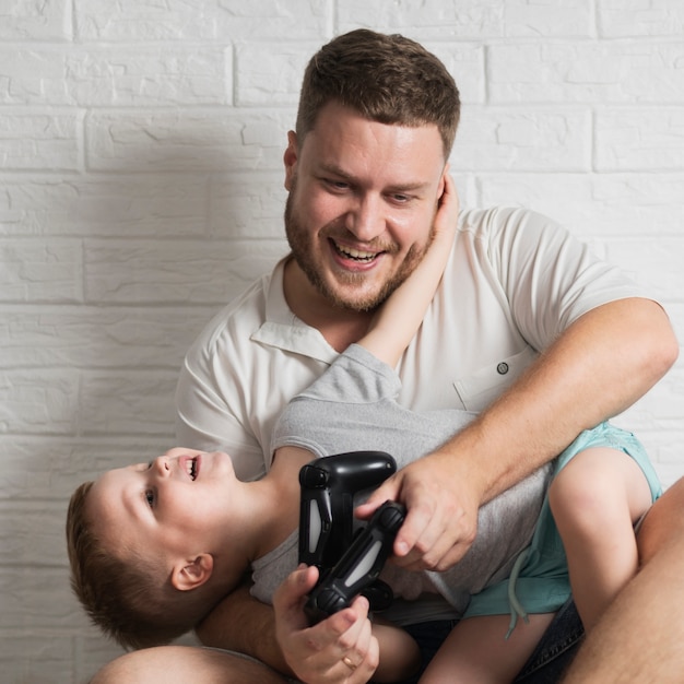 Photo gratuite père et fils à la maison jouant à des jeux numériques