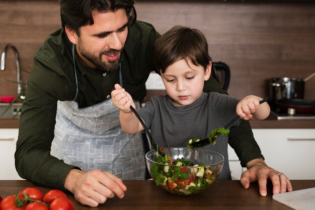 Père et fils à la maison préparant une salade