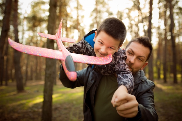 Père Et Fils Marchant Et S'amusant Dans La Forêt D'automne, L'air Heureux Et Sincère