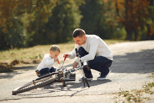 Père avec fils réparer le vélo dans un parc