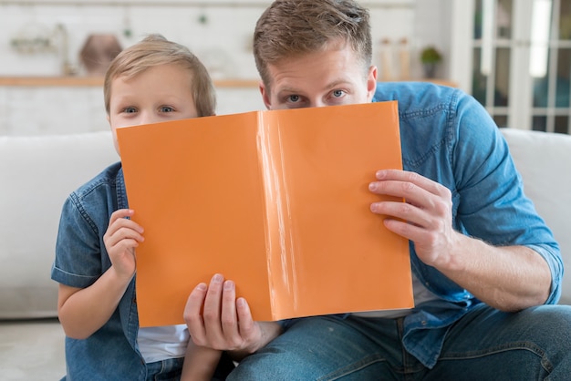 Père et fils se cachant derrière un ordinateur portable