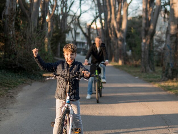 Père et fils à vélo dans le parc