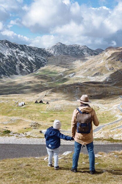 Père et fils voyagent ensemble dans les montagnes d'automne Durmitor Monténégro