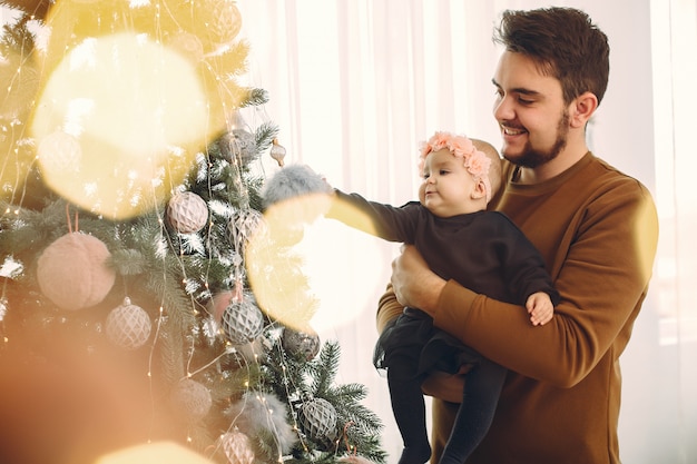 Père avec jolie fille près de sapin de Noël