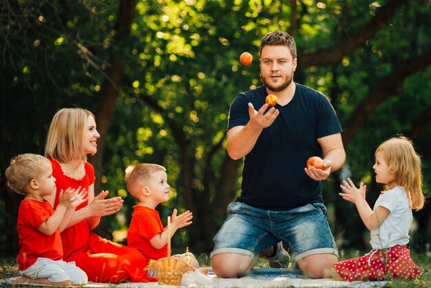 Père jonglant avec des oranges devant sa famille