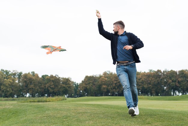 Père jouant avec un cerf-volant dans le parc