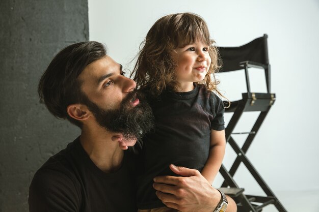 Père jouant avec son jeune fils dans leur salon à la maison. Jeune papa s'amusant avec ses enfants en vacances ou en week-end. Concept de parentalité, enfance, fête des pères et relation familiale.