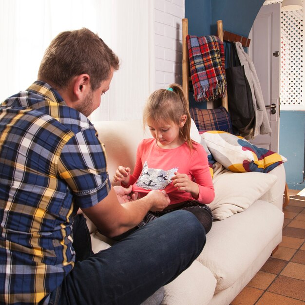 Père jouant avec le t-shirt de sa fille