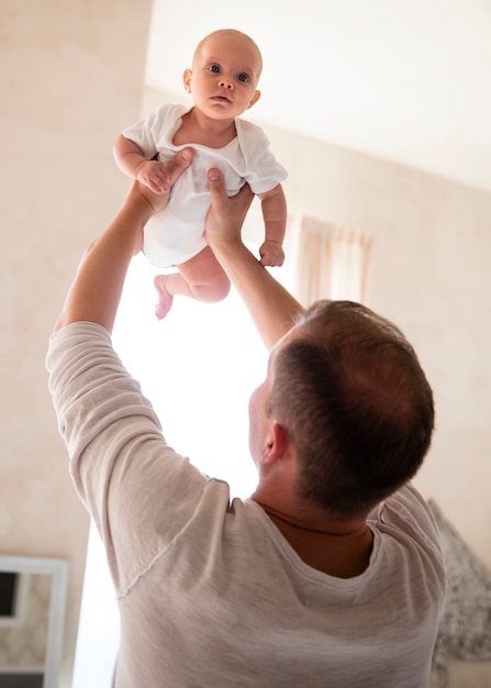 Photo gratuite père joue avec bébé à l'intérieur