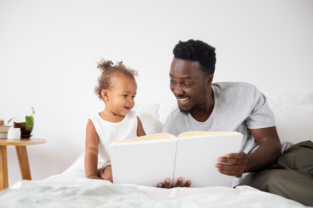 Photo gratuite père lisant à sa petite fille