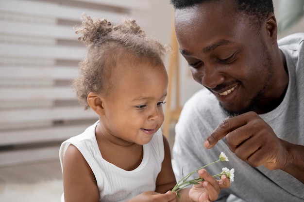 Photo gratuite père montrant des fleurs à sa petite fille