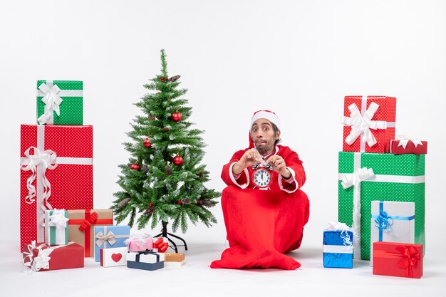 Photo gratuite père noël assis avec des coffrets cadeaux et des arbres