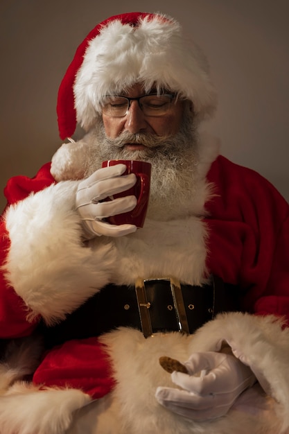 Photo gratuite père noël buvant une tasse de café