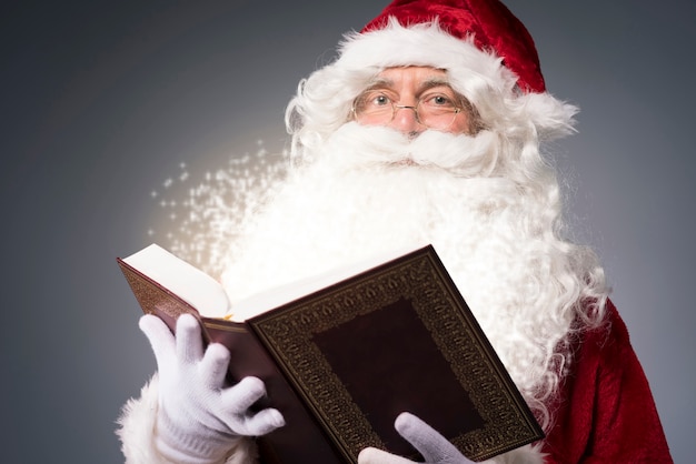 Photo gratuite père noël lisant des contes de noël