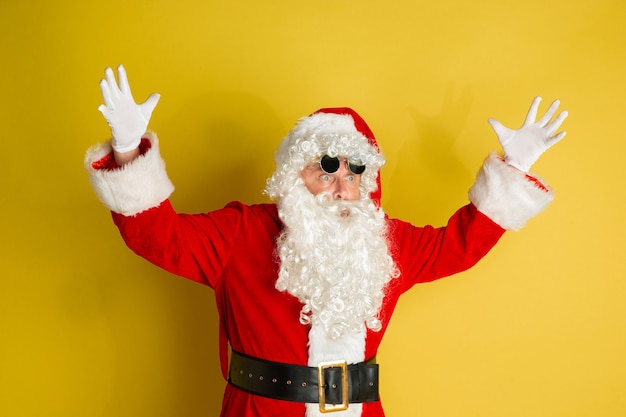 Père Noël avec des lunettes modernes isolées sur jaune