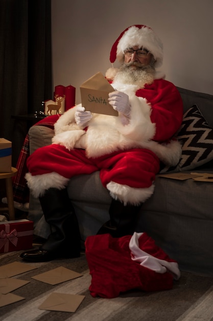 Photo gratuite père noël ouvrant une lettre d'un enfant