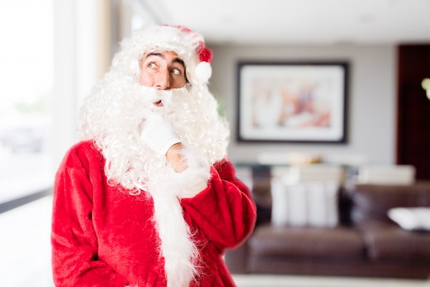 Père Noël réfléchie dans une maison