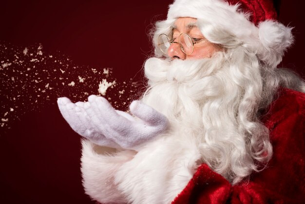 Père Noël soufflant des flocons de neige