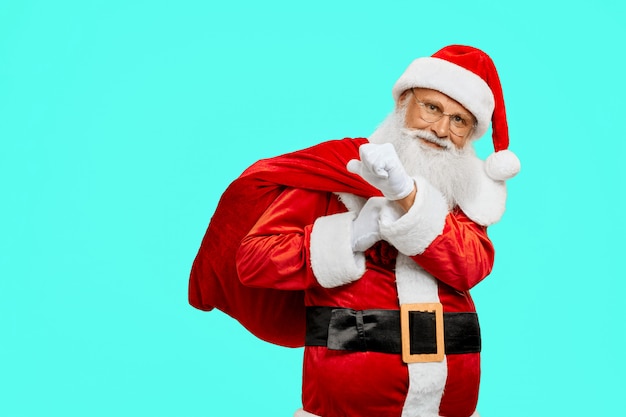 Père Noël souriant tenant le sac avec des cadeaux.