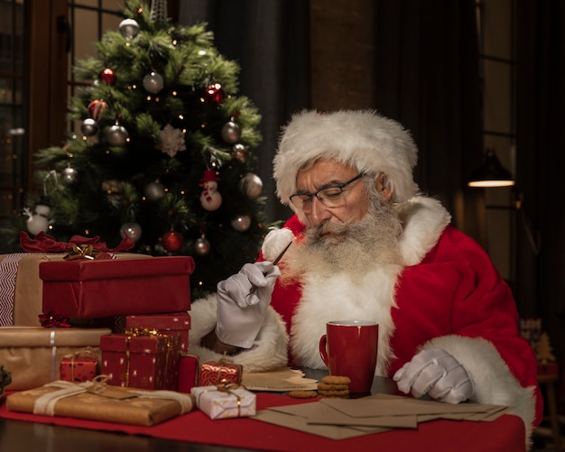 Père Noël à la table en pensant