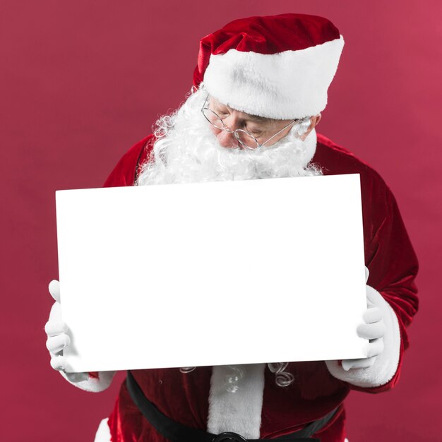 Père Noël tenant un papier blanc vierge en mains