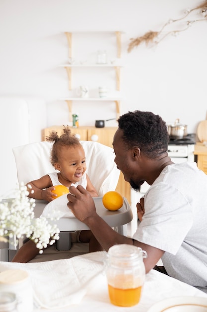 Père nourrissant sa petite fille dans la cuisine