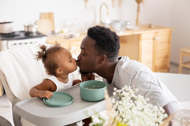 Père nourrissant sa petite fille dans la cuisine