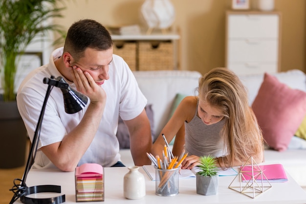 Photo gratuite père regardant les dessins de sa fille