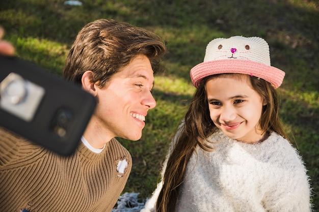 Père regardant sa fille tout en prenant selfie