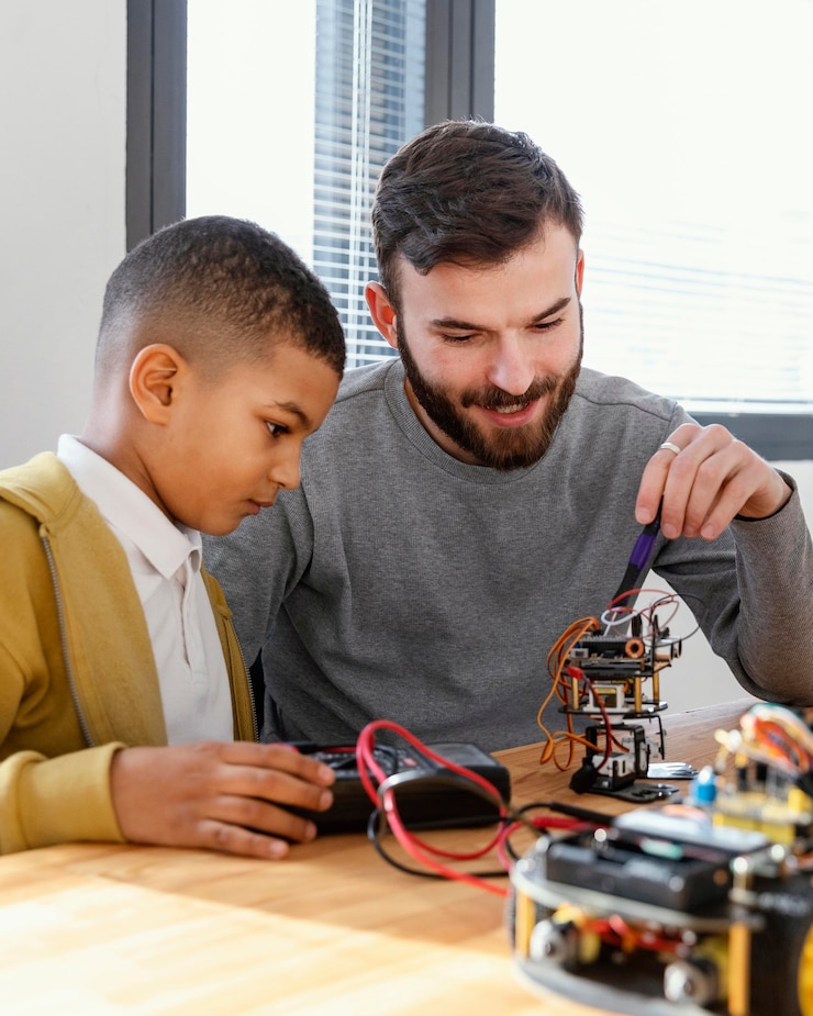 Photo gratuit un père et son fils fabriquent un robot.