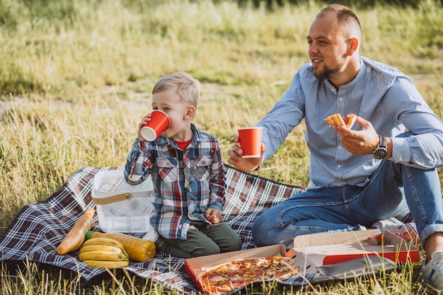 Père avec son fils pique-nique dans le parc