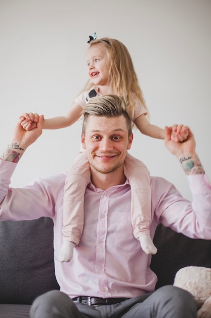 Photo gratuite le père souriant joue avec sa fille