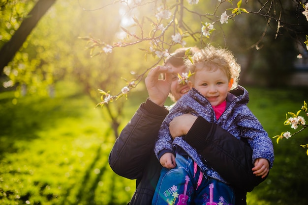 Photo gratuite père tenant son fils et saisissant une branche