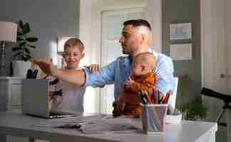 Photo gratuite père travaillant à domicile essayant d'équilibrer la vie de famille avec l'enfant et le travail