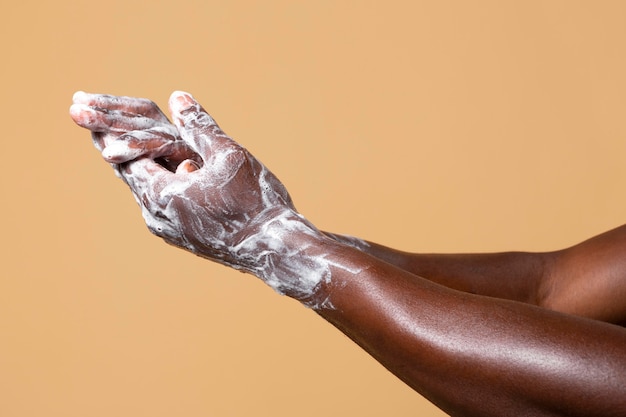 Personne africaine se lavant les mains avec du savon isolé sur orange