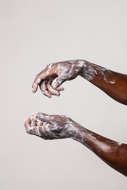 Personne africaine se laver les mains avec du savon isolé sur blanc
