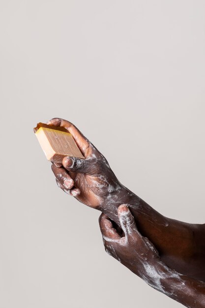 Personne africaine se laver les mains avec du savon isolé sur blanc