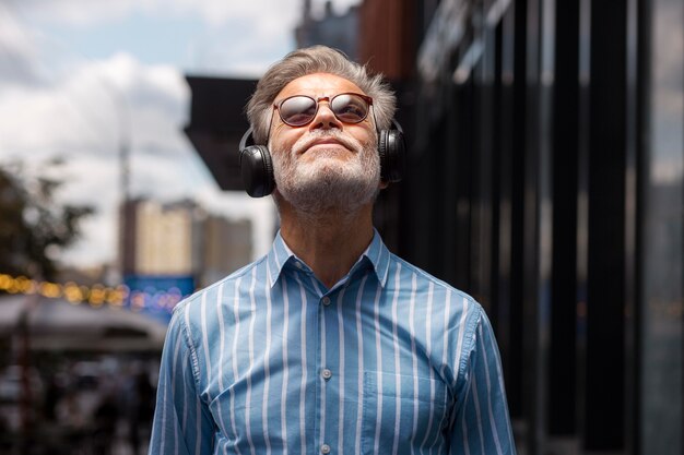 Personne âgée heureuse écoutant de la musique