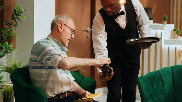 Photo gratuite personne âgée payant pour une tasse de café