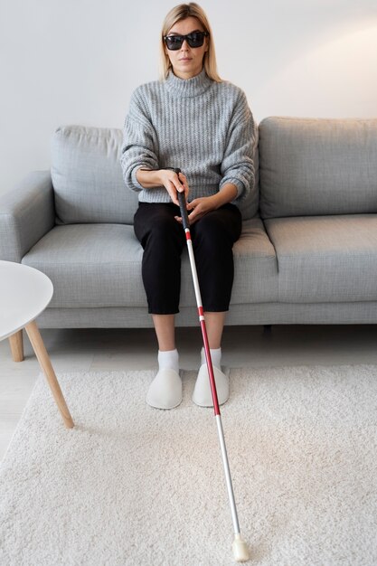 Une personne aveugle se prépare à marcher avec un bâton aveugle