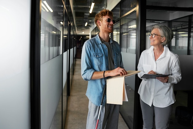 Photo gratuite personne aveugle travaillant dans un emploi de bureau inclusif