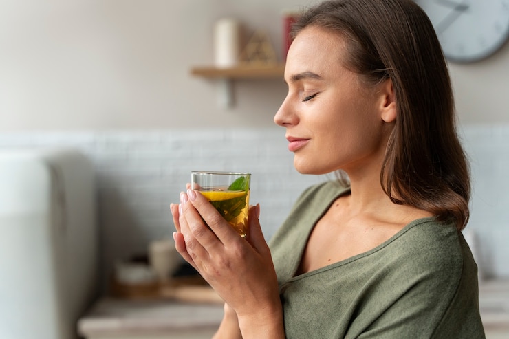 Photo gratuit une personne buvant du kombucha à la maison dans la cuisine
