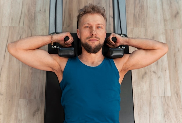 Photo gratuite personne en classe de réformateur pilates exerçant son corps