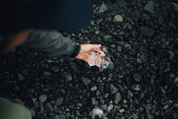 Photo gratuite personne détient un morceau de glace de glacier en islande