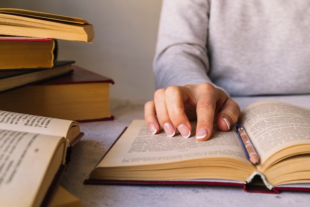 Personne étudiant à côté de la pile de livres