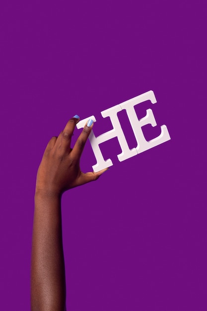 Personne fluide de genre tenant un pronom isolé sur violet